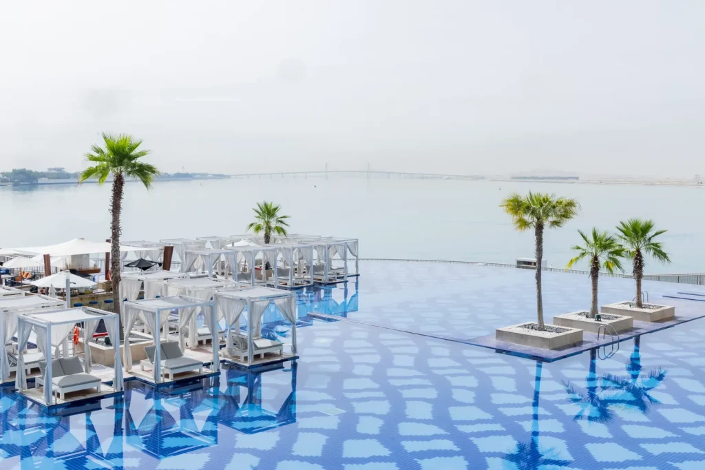 Infinity pool with cabanas and palm trees at Royal M Hotel Abu Dhabi